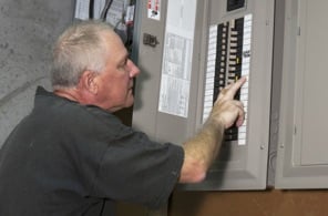 Man checking the electrical breakers in the fusebox