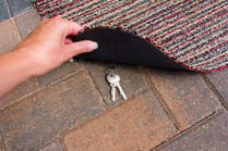 bigstock-Person-Lifting-A-Door-Mat-To-R-255481387